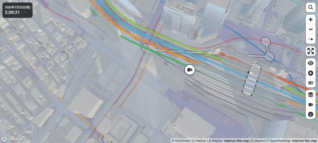 Mini Tokyo 3Dで都心部にズームインした3D表示。ビルの立体、駅、色分けされた複数路線が近距離で描かれ、リアルタイムの車両マーカーが載る